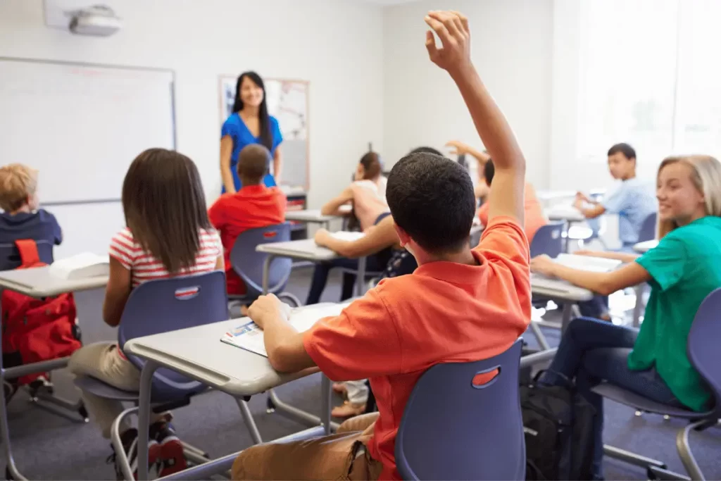 alunno alza una mano durante  la lezione
