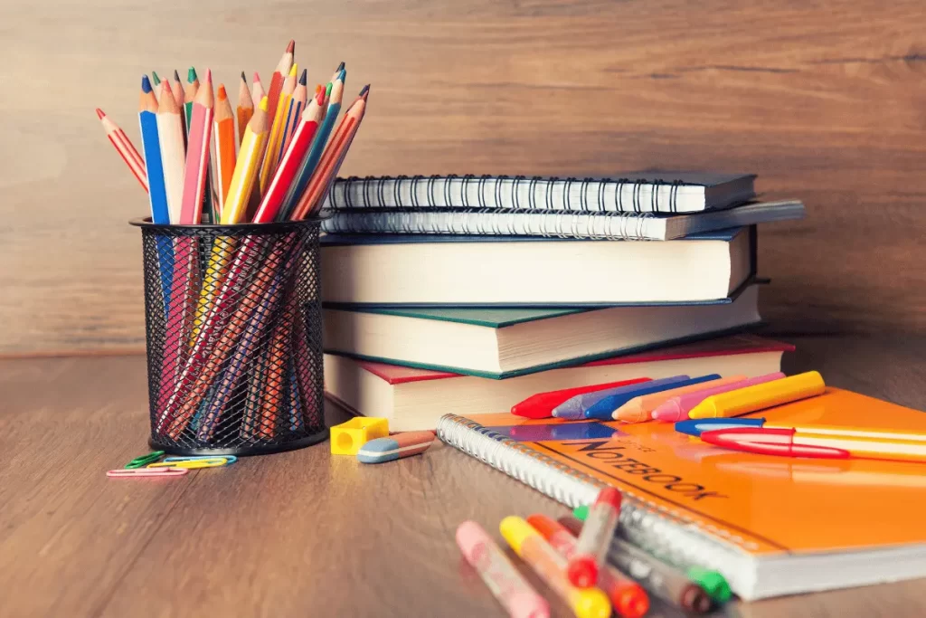 Libri, quaderni, penne e colori sulla scrivania