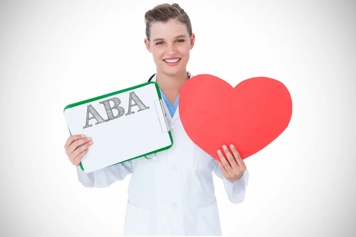 Tecnico ABA con in mano una lavagnetta con la scritta ABA e un cartoncino a forma di cuore