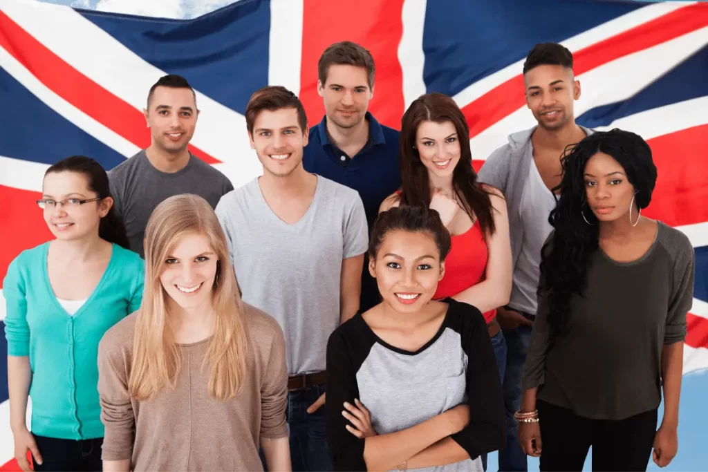 un gruppo di studenti di inglese davanti ad una bandiera inglese