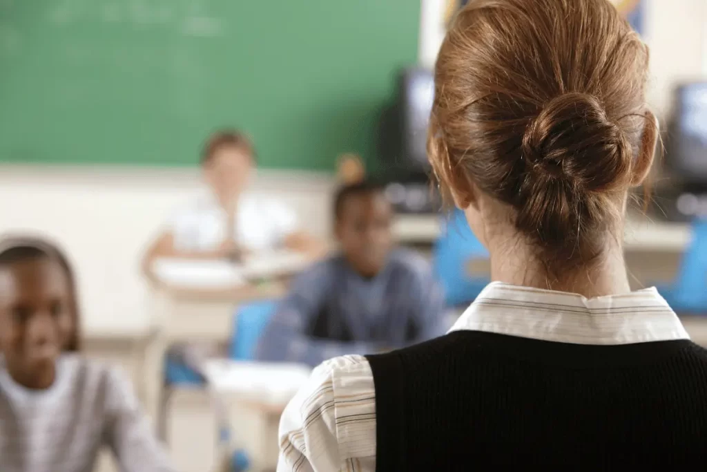 docente di spalle mentre parla con gli alunni