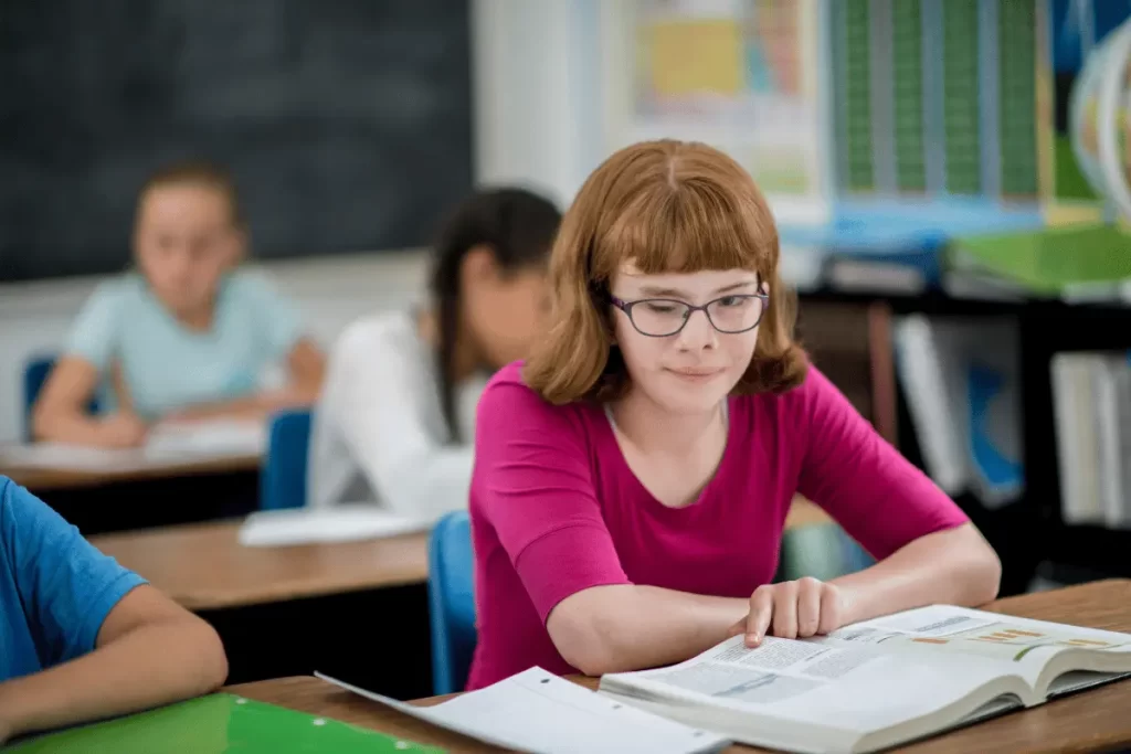 studentessa disabile in classe con un libro aperto