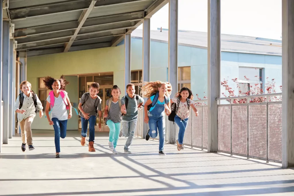 alunni corrono all'uscita della scuola