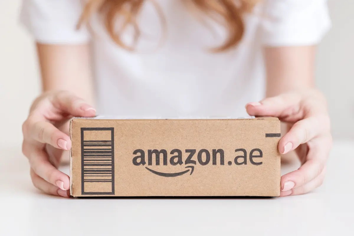 docente con in mano un pacco con il logo Amazon