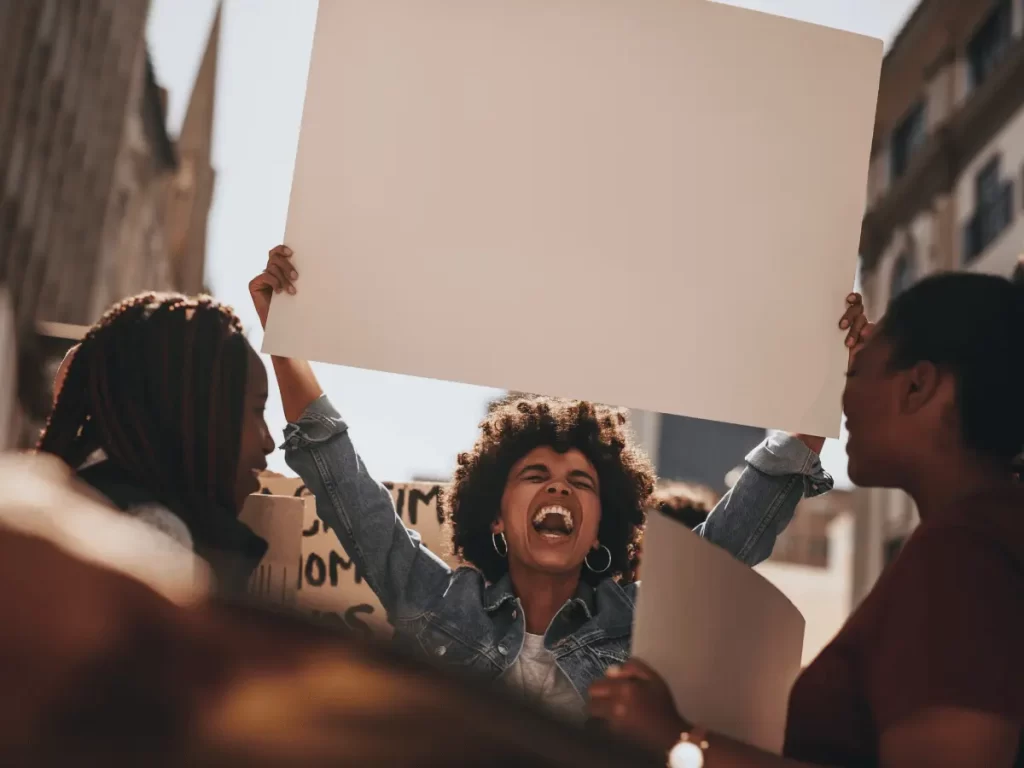 una docente mostra un cartellone durante una manifestazione di protesta