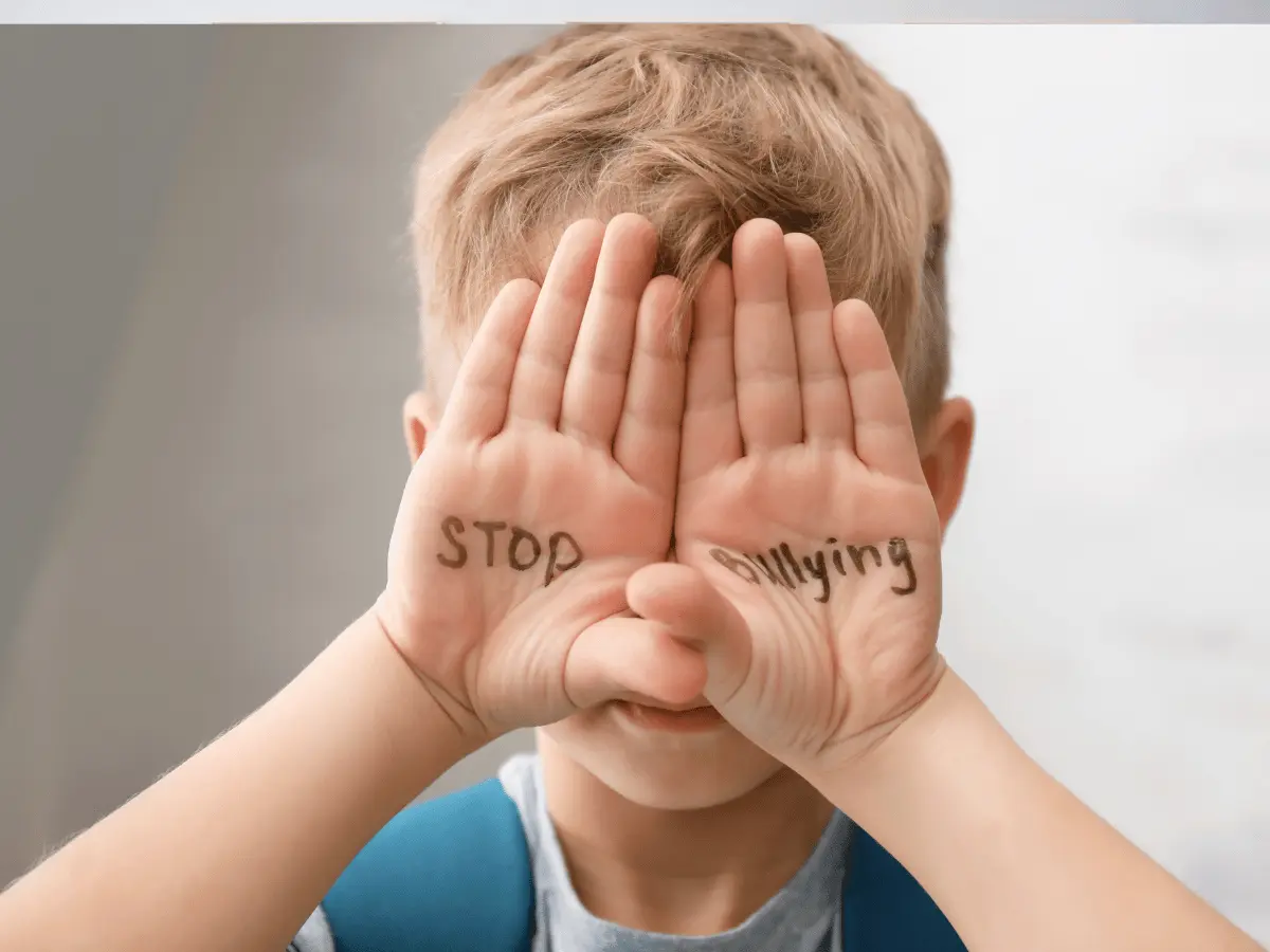Bimbo che ha scritto sulle mani stop al bullismo